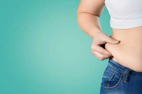 Image of woman pinching her love handles to show weight gain Halesowen